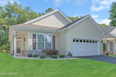 Ideally located in the Heritage Bay 55+ Community, this lovely home features brick and vinyl siding and a two car garage. There are 9 foot ceilings throughout, pull down attic access in the garage. | Image 1