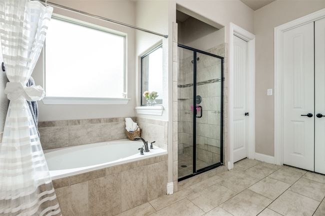 Bathroom featuring a bath, a stall shower, and tile patterned flooring | Image 17