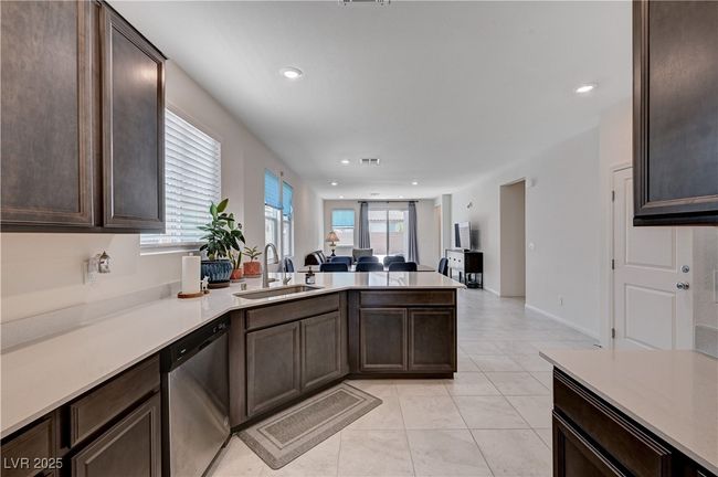 Kitchen featuring stainless steel dishwasher, a sink, a peninsula, dark brown cabinetry, and recessed lighting | Image 12