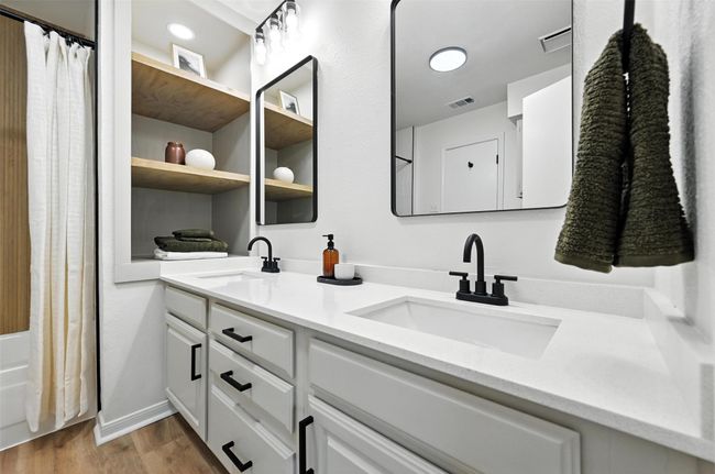 Bathroom with double vanity, wood finished floors, and shower / tub combo with curtain | Image 24