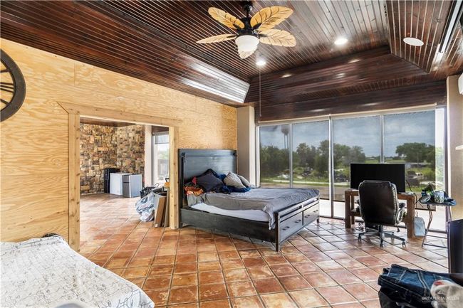 Bedroom featuring wood ceiling, access to outside, tile patterned floors, ceiling fan, and a tray ceiling | Image 14