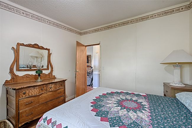 Bedroom featuring ornamental molding, a textured ceiling, and wood finished floors | Image 19