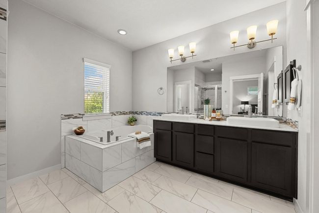 The ensuite bath offers a spa-like experience with a deep soaker tub, perfect for unwinding, alongside a separate shower for ultimate relaxation | Image 27