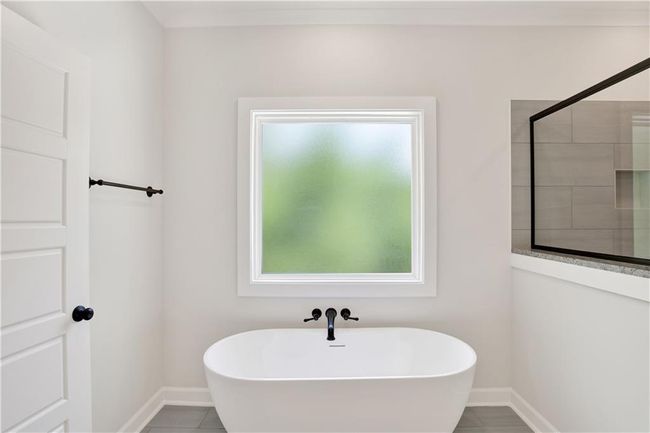 Full bathroom featuring a freestanding tub, a tile shower, and baseboards | Image 27