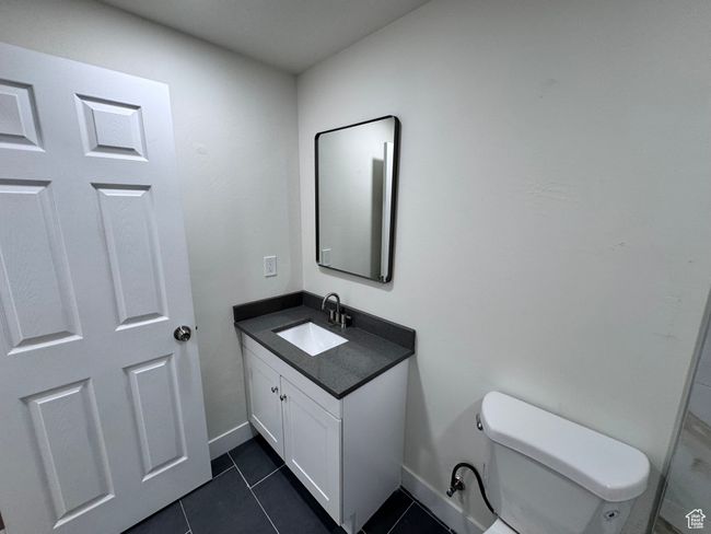 Bathroom featuring toilet, tile patterned flooring, vanity, and baseboards | Image 27