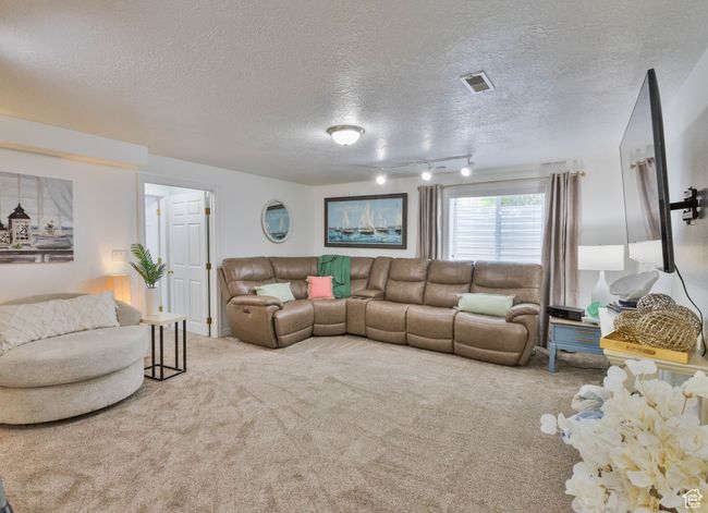 Living area with a textured ceiling and carpet | Image 44