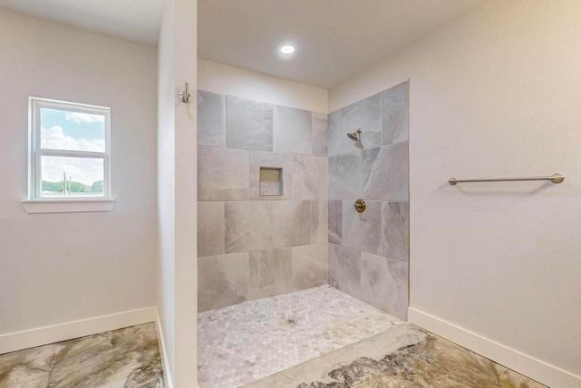 Bathroom with a tile shower, baseboards, recessed lighting, and marble finish floor | Image 20