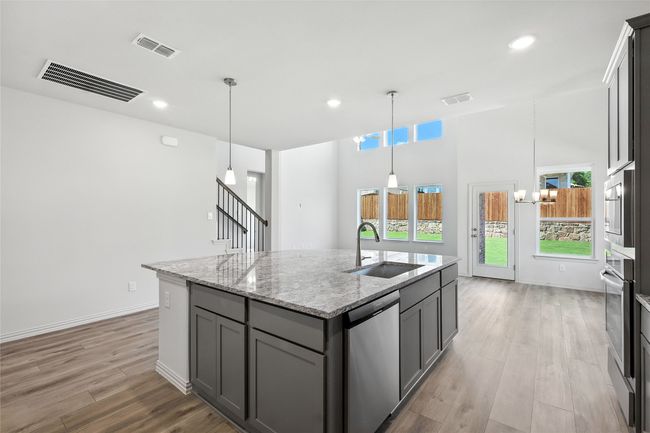 Kitchen featuring stainless steel appliances, gray cabinetry, an island with sink, plenty of natural light, and recessed lighting | Image 5