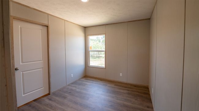 Unfurnished room with a decorative wall, light wood-style floors, and crown molding | Image 15