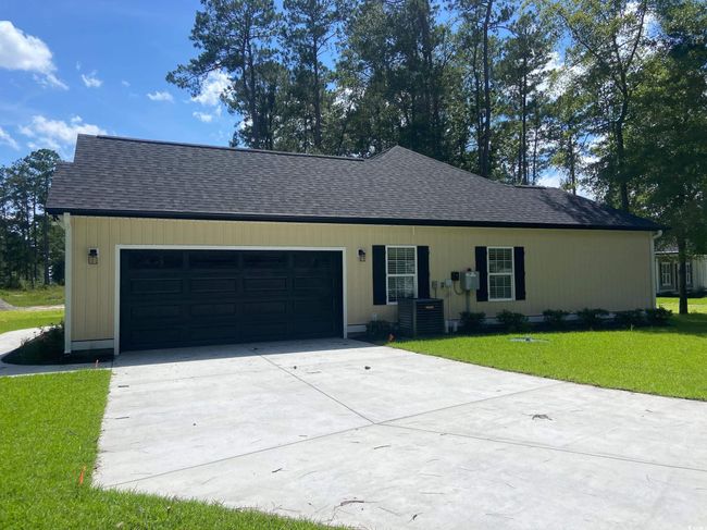 Ranch-style house featuring a garage, driveway, roof with shingles, and a front yard | Image 5