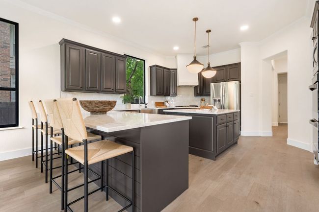 The heart of the home, this stunning kitchen is designed to inspire, with gleaming quartz countertops and a center island offering ample space for meal prep or casual dining. | Image 8