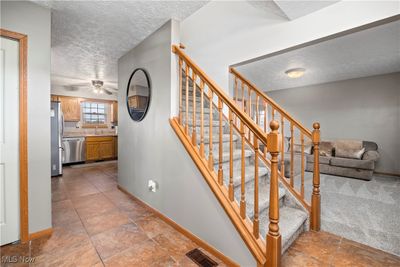 Staircase with carpet flooring, a textured ceiling, sink, and ceiling fan | Image 3