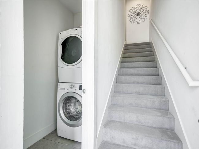 Laundry area featuring stacked washer / dryer and tile patterned flooring | Image 15