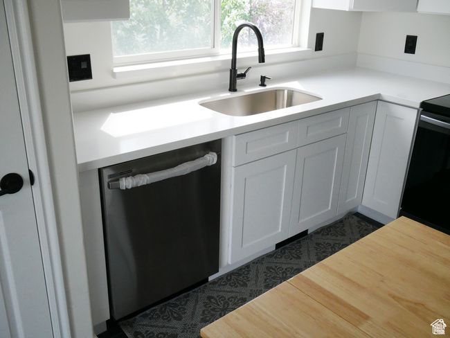 Kitchen featuring stainless steel dishwasher, range with electric cooktop, healthy amount of natural light, and light countertops | Image 10