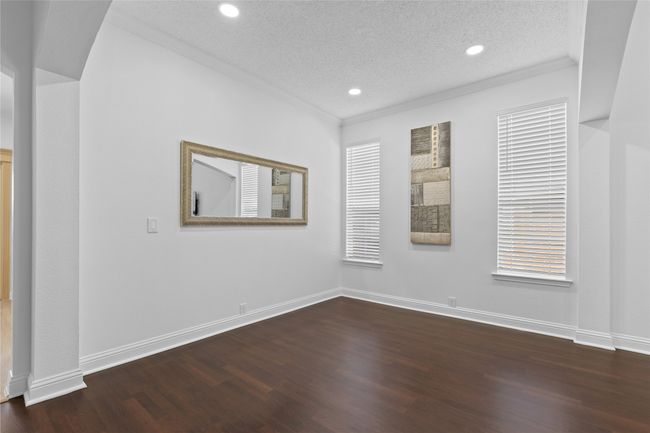 Unfurnished room with ornamental molding, a textured ceiling, dark wood-style flooring, and recessed lighting | Image 9