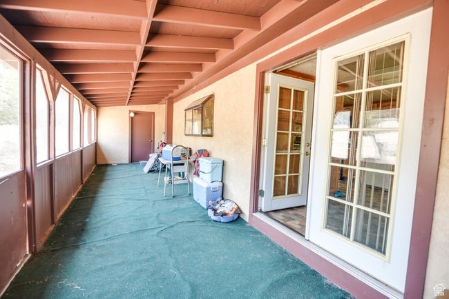 Unfurnished sunroom with beamed ceiling | Image 13