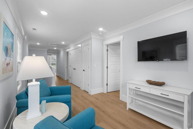 Living area featuring light wood-style floors, crown molding, and recessed lighting | Image 20