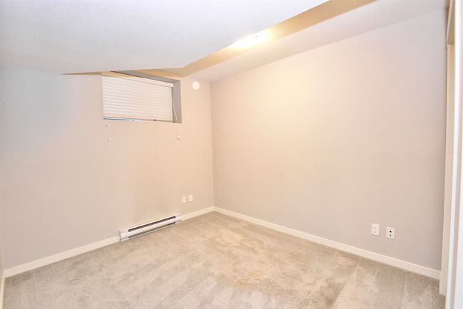 Empty room featuring a baseboard radiator and light colored carpet | Image 34