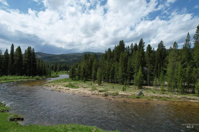Water view with a heavily wooded area and mountains | Image 28