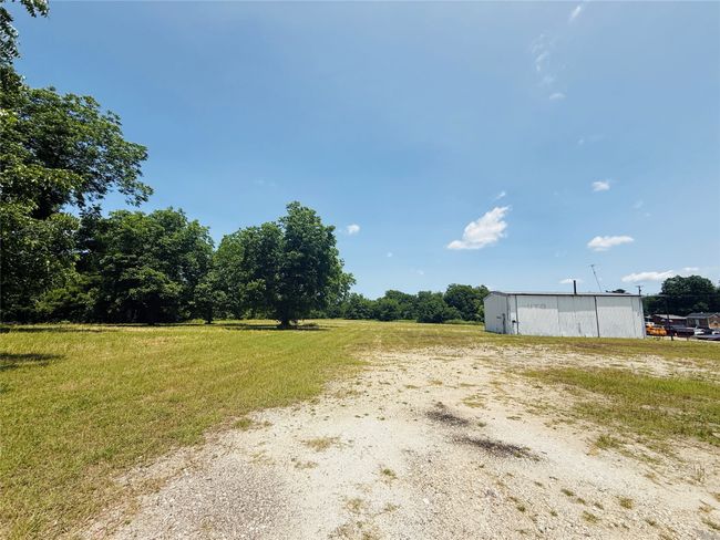 View of grassy yard with an outbuilding and a view of countryside | Image 7