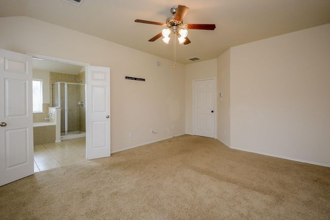A spacious master bedroom leads into the master baththrough paneled double doors. | Image 16