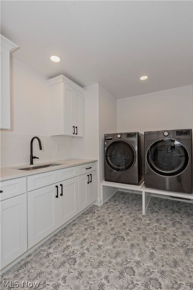 Washroom with washer and dryer, cabinets, sink, and light tile flooring | Image 46