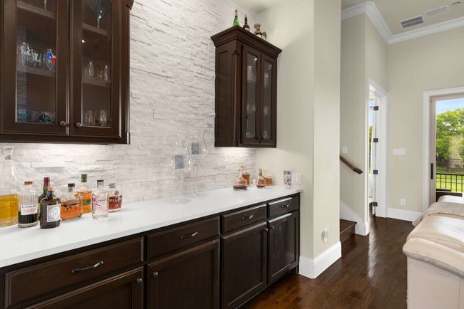 Dry bar featuring, stacked stone decorative backsplash, with an abundance of storage. | Image 11