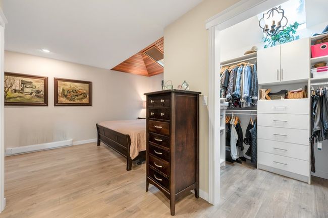 Bedroom with a spacious closet, baseboards, light wood-type flooring, a closet, and a baseboard radiator | Image 18