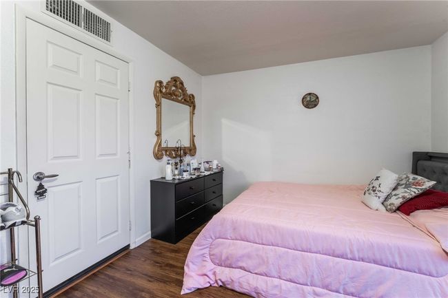 Bedroom featuring dark wood-style floors and visible vents | Image 32