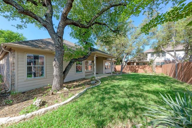 View of front of home with a front yard, a fenced backyard, a shingled roof, and a patio area | Image 33