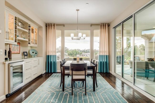 Built-in wine fridge and cabinetry in dining room. Two sliding glass walls to outdoor entertaining areas. | Image 19