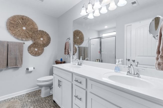 Primary bath, double vanities, decorative flooring and nice shower with a window. | Image 20