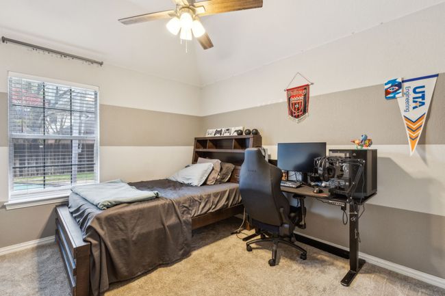 Bedroom with baseboards, carpet floors, vaulted ceiling, and a ceiling fan | Image 23