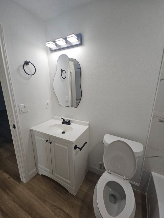 Bathroom featuring toilet, vanity, baseboards, and wood finished floors | Image 15