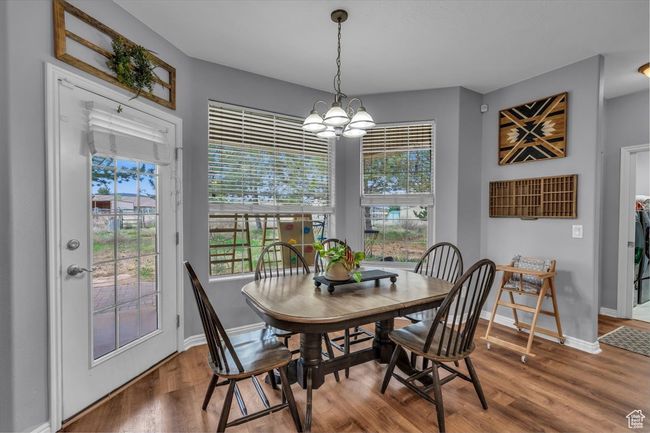 Dining space featuring wood finished floors, baseboards, and an inviting chandelier | Image 15