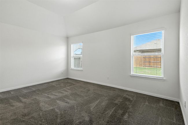 Empty room featuring dark carpet, healthy amount of natural light, and lofted ceiling | Image 27