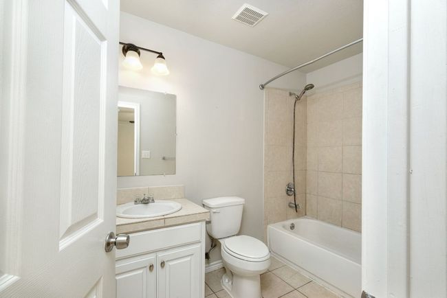 Full bathroom with tile patterned floors, vanity, and shower / bath combination | Image 12