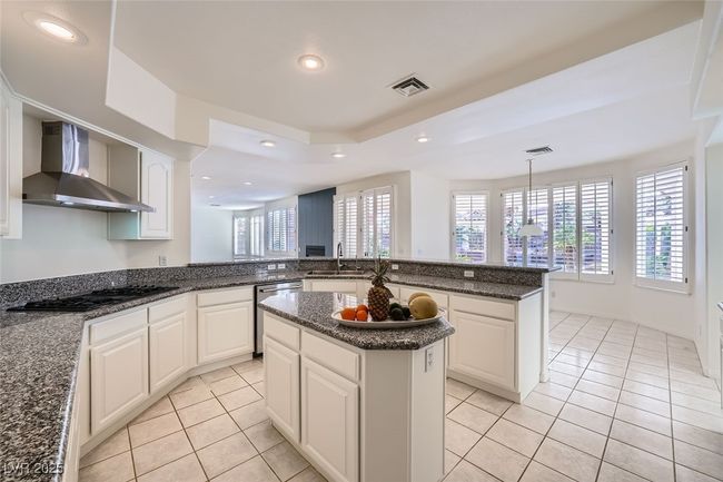 Kitchen featuring black gas stovetop, a sink, visible vents, wall chimney range hood, and dishwasher | Image 26