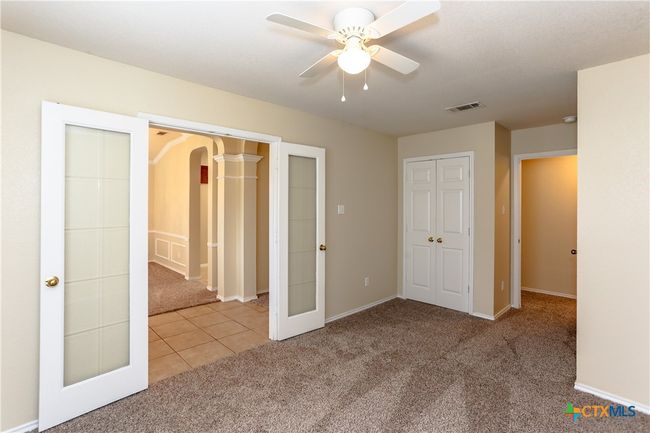 First bedroom right off the entry way with French doors. Another door leads to the hallway. | Image 10