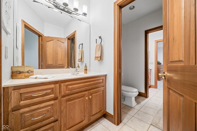 bathroom with vanity, toilet, tile patterned flooring, and baseboards | Image 87