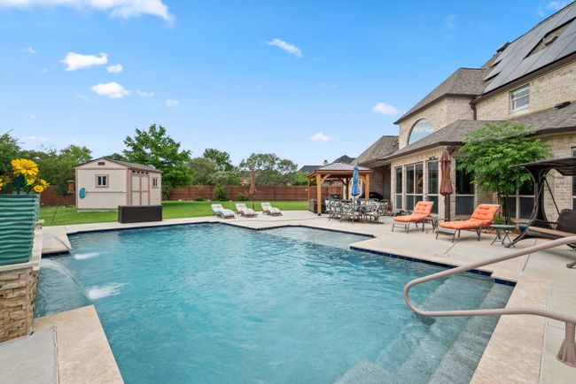 View of swimming pool with a gazebo, a patio area, a fenced backyard, and a storage shed | Image 8