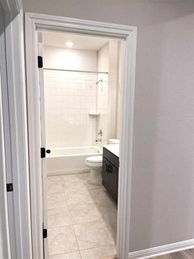Full bath featuring vanity, tub / shower combination, and tile patterned floors | Image 7