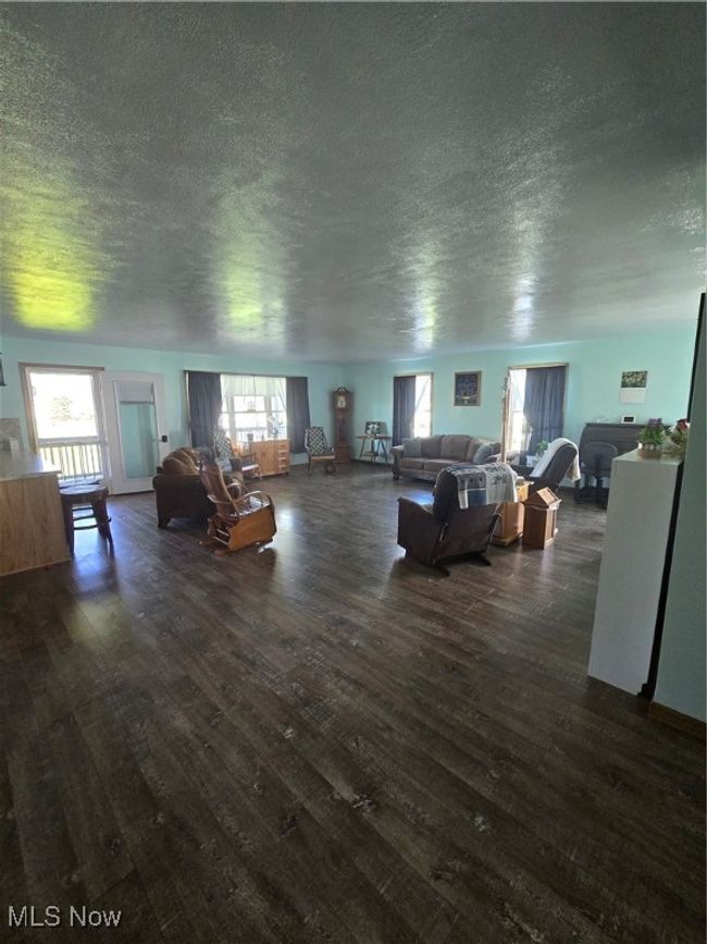 Living area with a wealth of natural light, a textured ceiling, and dark wood finished floors | Image 33