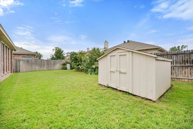 Fenced backyard with a storage unit | Image 23