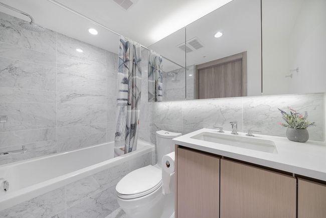 Bathroom featuring shower / tub combo, tile walls, toilet, vanity, and recessed lighting | Image 14