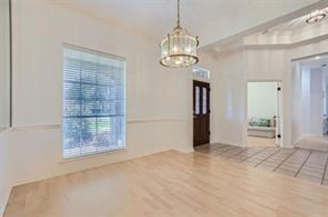 Unfurnished dining area with a chandelier and wood finished floors | Image 21