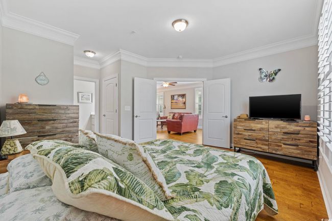 Bedroom with ornamental molding and wood finished floors | Image 16