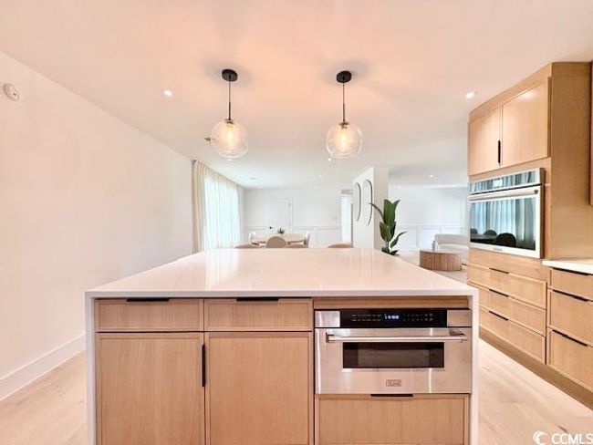 Kitchen with stainless steel oven, light brown cabinets, and light wood-style flooring | Image 12