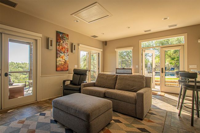 Living area with healthy amount of natural light, wainscoting, recessed lighting, and stone tile flooring | Image 32
