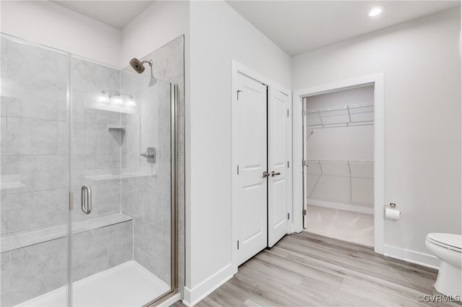 Bathroom with a stall shower, wood finished floors, recessed lighting, and a walk in closet | Image 29